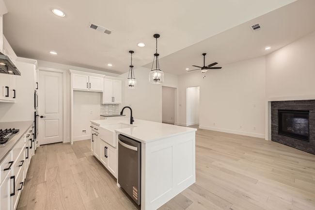 Kitchen with stainless steel appliances, ceiling fan, a sink, open floor plan, and light wood-type flooring | Image 14