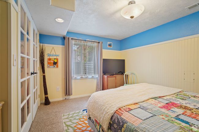 Bedroom with visible vents, carpet, baseboards, a textured ceiling, and french doors | Image 25