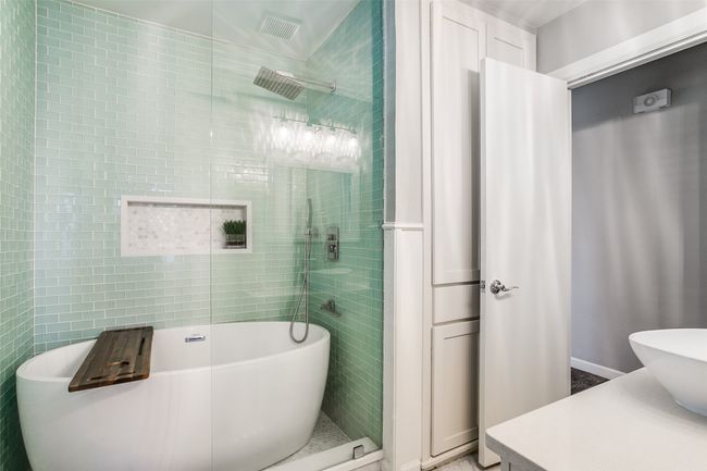 Bathroom featuring a soaking tub, a tile shower, and tile walls | Image 22
