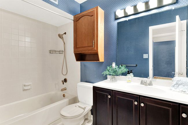 Bathroom featuring wallpapered walls, vanity, and shower / bathtub combination | Image 33