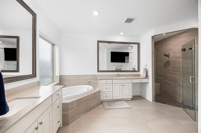 Impeccable primary bath with double sinks, vanity, soaker tub and large walk-in shower. | Image 32