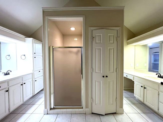 Bathroom with a shower stall, tile patterned flooring, and two vanities | Image 28