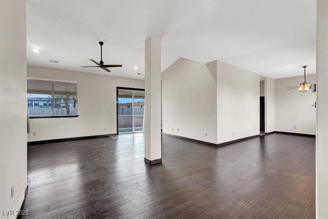 Empty room with dark wood-type flooring, ceiling fan | Image 7