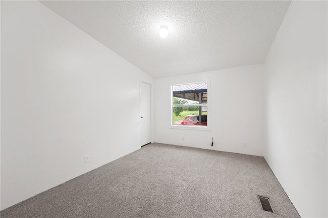 Bedroom 3 with light colored carpet, a textured ceiling, and vaulted ceiling | Image 20