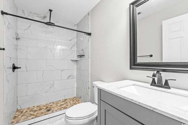 Full bath featuring vanity, a stall shower, and a textured ceiling | Image 24