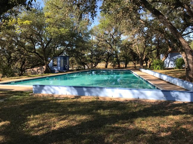 Community pool with a yard, a storage shed, and view of wooded area | Image 32