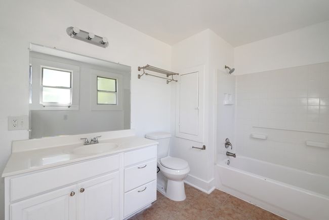 Bathroom featuring toilet, vanity, washtub / shower combination, and tile patterned flooring | Image 12