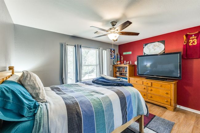 Bedroom with wood finished floors, ceiling fan, and baseboards | Image 17