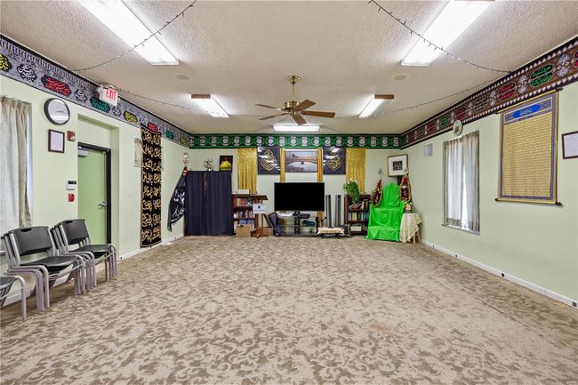 Recreation room with a ceiling fan, carpet, visible vents, and a textured ceiling | Image 27