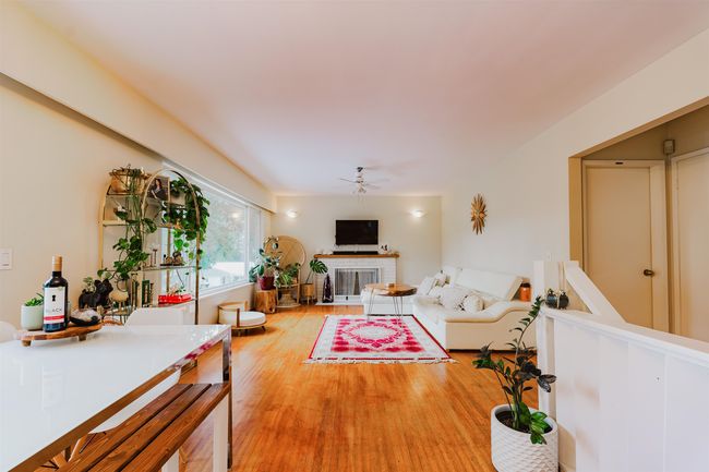 Living area with light wood finished floors, a brick fireplace, and ceiling fan | Image 8
