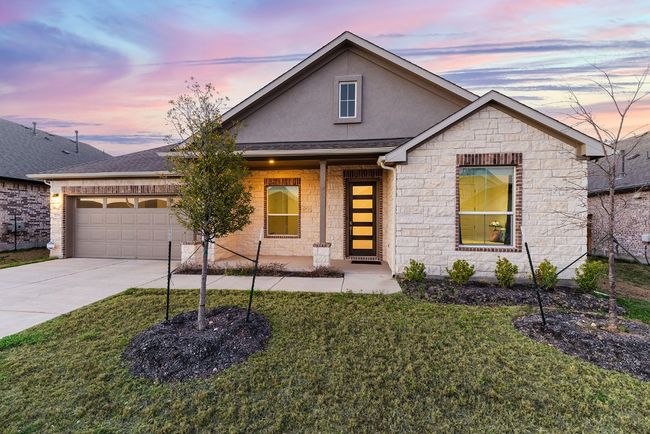 View of front of house featuring an attached garage, a yard, stucco siding, concrete driveway, and stone siding | Image 7