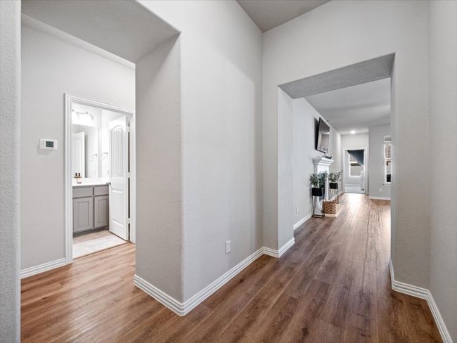 Corridor featuring baseboards and wood finished floors | Image 4