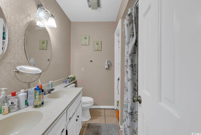 Bathroom featuring a sink, toilet, tile patterned floors, and wallpapered walls | Image 28