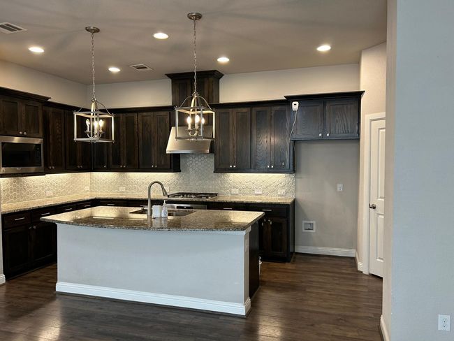 Kitchen featuring stainless steel microwave, a sink, a chandelier, dark stone countertops, and recessed​​‌​​​​‌​​‌‌​‌‌​​​‌‌​​‌‌​‌​​​​​‌ lighting | Image 12