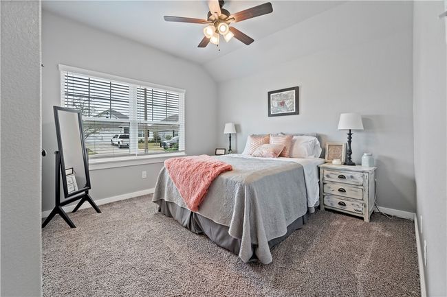 Bedroom featuring baseboards, carpet floors, vaulted ceiling, and a ceiling fan | Image 6