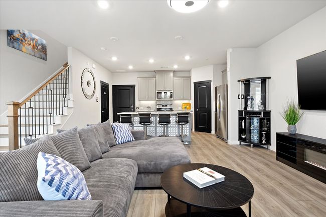 Living area with light wood-type flooring, recessed lighting, and stairway | Image 7