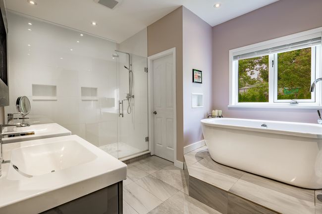Bathroom with a stall shower, a freestanding bath, double vanity, recessed lighting, and marble finish floors | Image 17