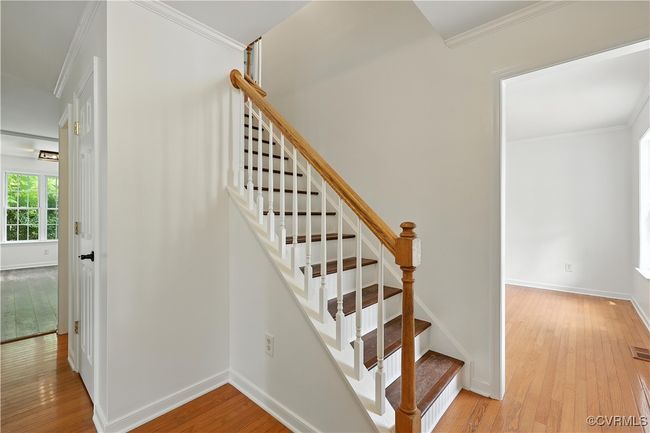 Stairway with hardwood / wood-style flooring and crown molding | Image 15