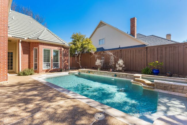 View of pool with a fenced backyard, a pool with connected hot tub, and a patio | Image 30