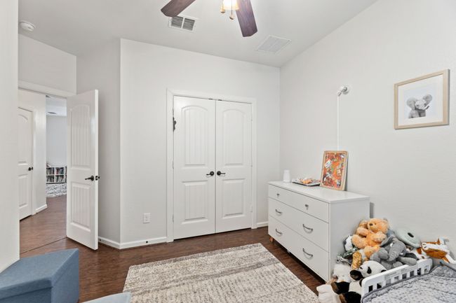 Bedroom featuring dark wood-style floors, a closet, a ceiling fan, and baseboards | Image 26