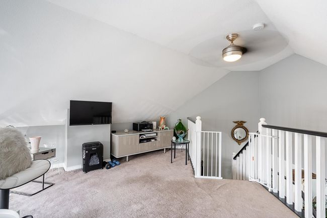 Additional living space featuring baseboards, light carpet, lofted ceiling, and a ceiling fan | Image 25