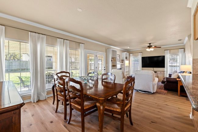 Dining space featuring light wood-type flooring, ceiling fan, and crown molding | Image 9