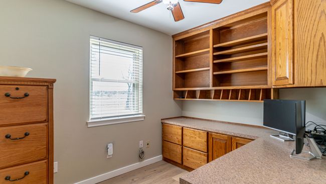 Home office featuring baseboards, a ceiling fan, and light wood-style floors | Image 26