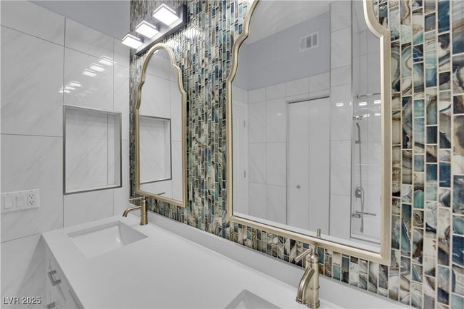 Bathroom featuring vanity, a tile shower, and tile walls | Image 24
