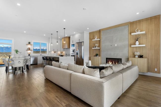Living area with dark wood-style floors, recessed lighting, and a fireplace | Image 11