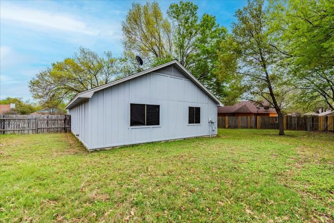 Back of house with board and batten siding, a fenced backyard, and a yard | Image 26