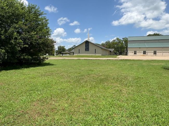 View of grassy yard featuring a pole building and an outbuilding | Image 10