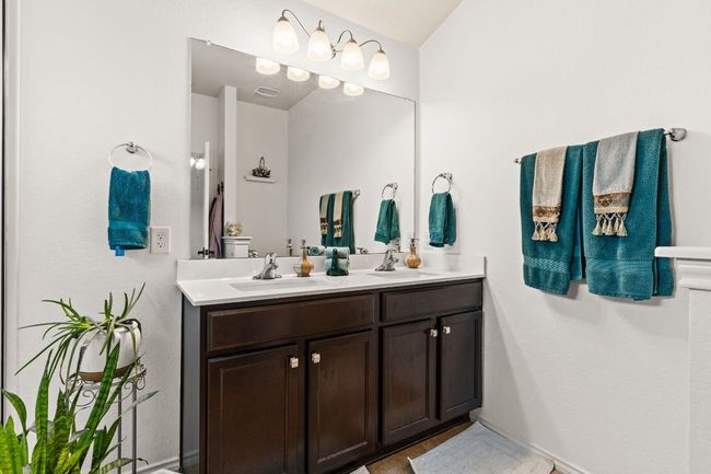 Bathroom with double vanity, a sink, and visible vents | Image 15