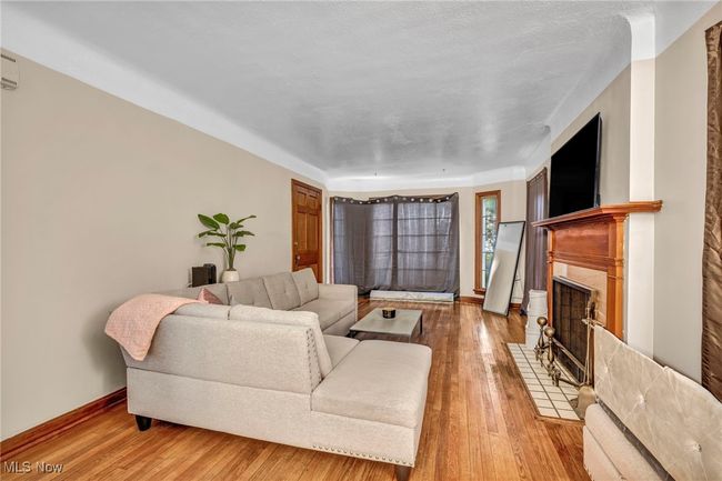 Living room featuring a fireplace with flush hearth, baseboards, and light wood finished floors | Image 7