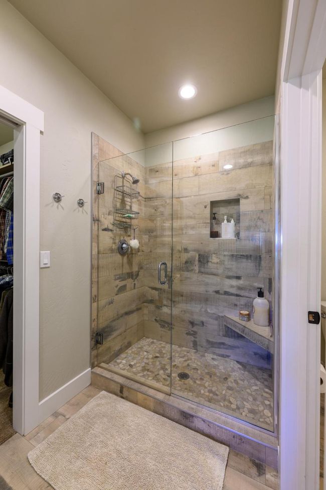 Bathroom with a stall shower, a spacious closet, recessed lighting, wood finished floors | Image 21