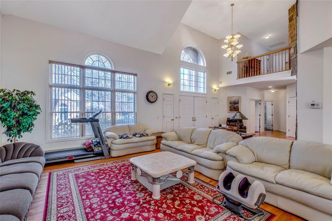 Living room with hardwood / wood-style floors, high vaulted ceiling, and a chandelier | Image 5