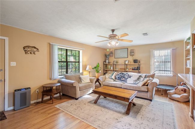 Living area with light wood-style flooring and a ceiling fan | Image 12