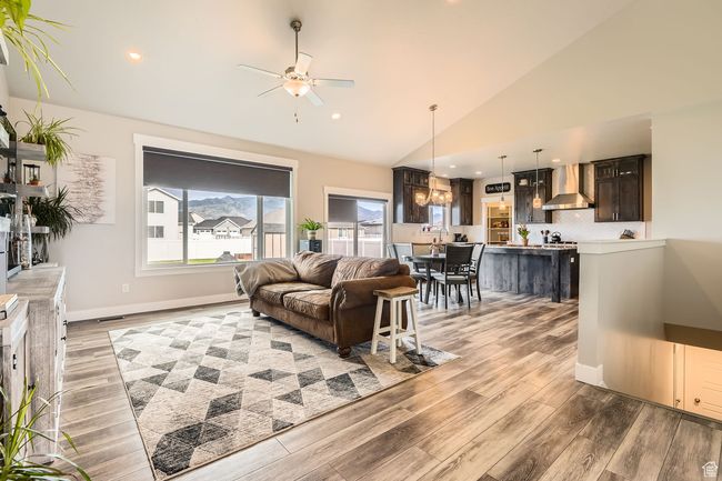 Living room featuring ceiling fan, light wood finished floors, recessed lighting, and high vaulted ceiling | Image 4