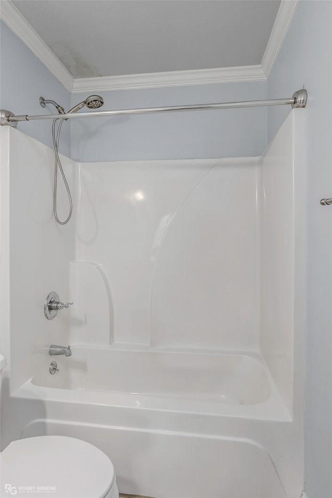 Bathroom featuring toilet, crown molding, and shower / bathtub combination | Image 13