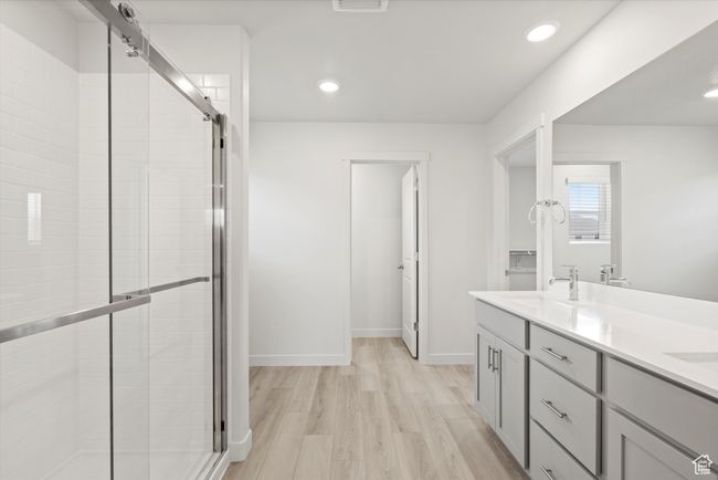 Full bath featuring a shower stall, double vanity, wood finished floors, and recessed lighting | Image 34