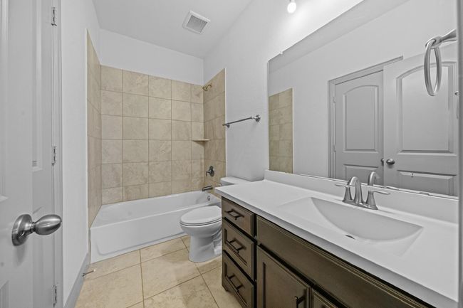 Full bathroom with tile patterned floors, shower combination, toilet, visible vents, and vanity | Image 19
