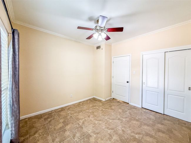 Unfurnished bedroom featuring crown molding, a closet, and a ceiling fan | Image 20