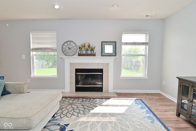 living area with a tiled fireplace, wood finished floors, baseboards, and recessed lighting | Image 12