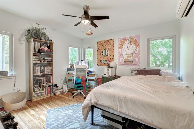 Bedroom featuring wood finished floors, ceiling fan, and a wall mounted air conditioner | Image 35