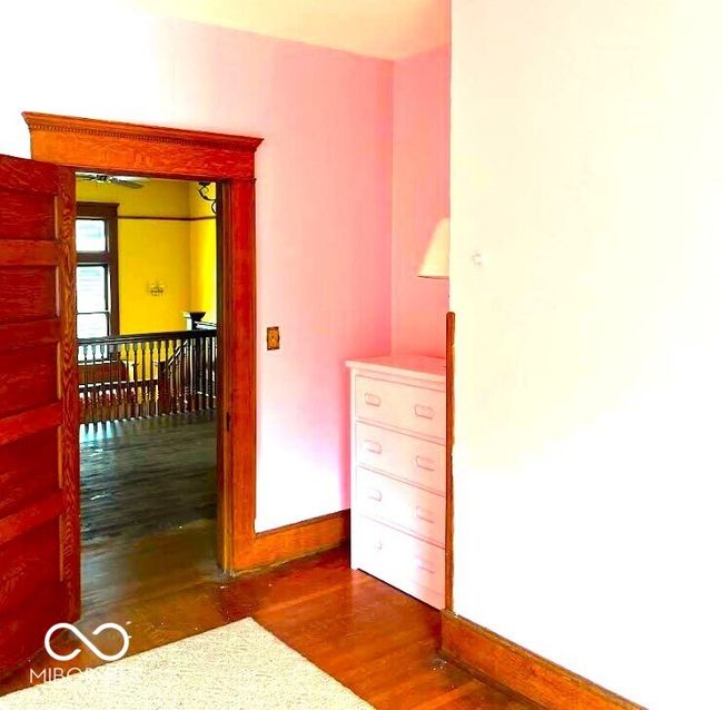 interior space featuring baseboards, an upstairs landing, and wood finished floors | Image 13