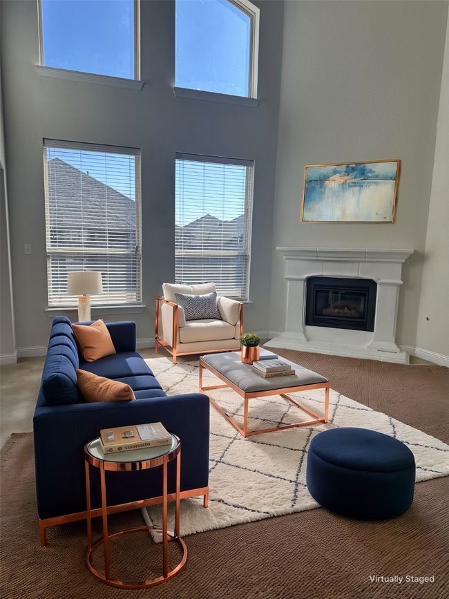 Living area featuring a high ceiling, a fireplace, carpet flooring, and baseboards | Image 12