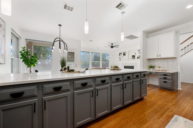 Kitchen with tasteful backsplash, gray cabinetry, white cabinetry, and visible vents | Image 12
