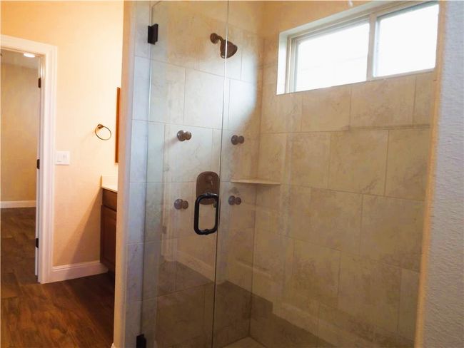 Full bath with wood finished floors, a shower stall, vanity, and baseboards | Image 7