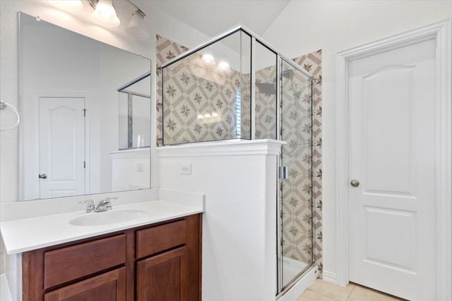 Bathroom featuring vanity, tile patterned flooring, and a stall shower | Image 19
