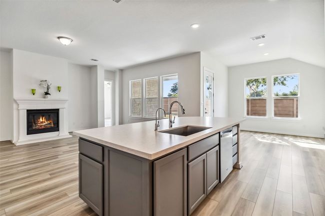 Kitchen with open floor plan, gray cabinetry, a kitchen island with sink, light countertops, and recessed lighting | Image 13