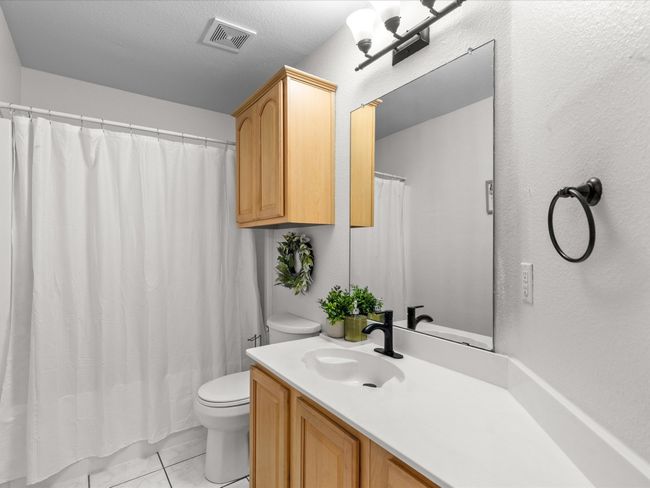 Full bathroom featuring vanity, curtained shower, and marble look tile flooring | Image 24
